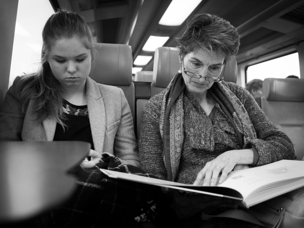 Mother and Daughter traveling by train. The mother just showed her daughter her specially made family history book. Her daughter was not interested.