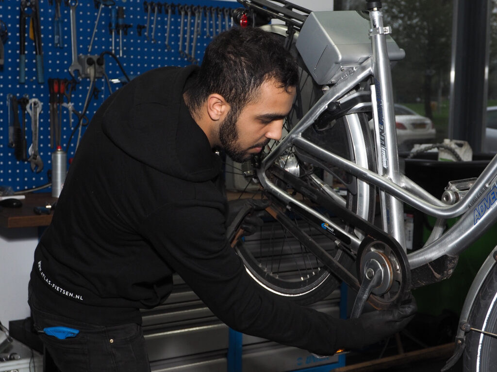 Man repairing a bicycle at Atlas Fietsen. 