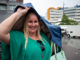 Vibrant Woman Shielding Herself from the Rain with Her Coat